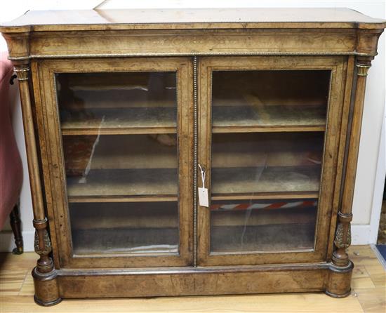 A walnut inlaid glazed two door bookcase, W.122cm